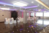 a banquet hall with white tables and white chairs at Pavitram Hotel & Banquet in Rānchī