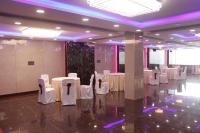 a room with white tables and chairs and purple lighting at Pavitram Hotel & Banquet in Rānchī