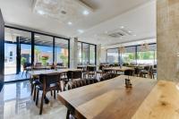 restauracja ze stołami i krzesłami oraz dużymi oknami w obiekcie M&N Holiday Resort w Ulcinju