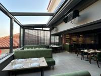 メルジフォンにあるKORKMAZ OTELの緑の椅子とテーブル、窓のあるレストラン