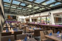 ベルリンにあるパーク イン バイ ラディソン ベルリン アレクサンダープラッツのテーブルと椅子と窓がある空のレストラン