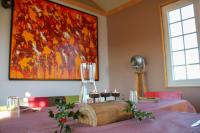 un tavolo con un bicchiere di vino e un dipinto sul muro di Chalet Miro a Saint-Germain-dʼAunay