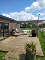 una terrazza in legno con tavolo e sedie. di Chalet Miro a Saint-Germain-dʼAunay