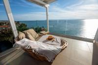 Un balcón con mesa y vista al mar. en Thea Suites Potidea, en Nea Potidaea