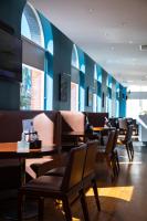 a restaurant with tables and chairs and blue walls at Ramada by Wyndham Belfast in Belfast