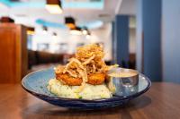 a blue plate with food on a wooden table at Ramada by Wyndham Belfast in Belfast