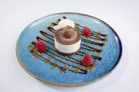 a dessert on a blue plate with strawberries and whipped cream at Ramada by Wyndham Belfast in Belfast