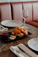 een bord eten op tafel met een glas wijn bij Vintage Boutique Hotel in Korçë