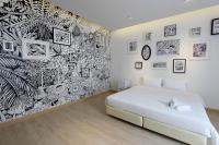 a bedroom with a white bed and a black and white wall at Beat Hotel Bangkok in Bangkok