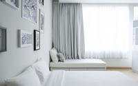a white bedroom with two beds and a window at Beat Hotel Bangkok in Bangkok