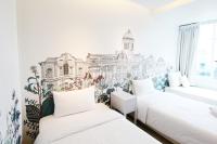 a bedroom with two beds and a mural of a building at Beat Hotel Bangkok in Bangkok