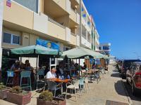 a group of people sitting at tables under umbrellas at Corralejo Coliving by Amazzzing Travel in Corralejo