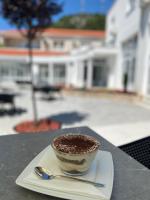 una tazza di caffè seduta su un piatto con un cucchiaio di Ragusa Villa a Stolac