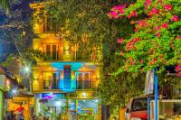 a building at night with pink flowers in front of it at Beach Comforts By Balaji Inn in Calangute