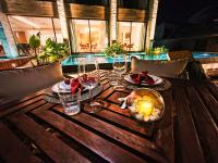 einem Holztisch mit Weingläsern und einer Kerze darauf in der Unterkunft Almareia Boutique Hotel in Praia dos Carneiros