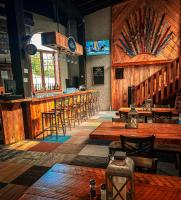un bar con tavoli e sedie in legno in un ristorante di Whitecap Mountains Resort a Upson