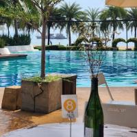 eine Flasche Wein auf einem Tisch neben einem Pool in der Unterkunft Beautiful 2 Bedroom Seaview Jomtien 18th floor 78sqm พัทยา in Jomtien Beach