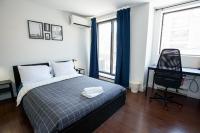 Un dormitorio con una cama, un escritorio y una silla. en Samesun Toronto, en Toronto