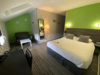 Una habitación de hotel con una cama grande y una silla. en Hôtel Bagatelle, en Pont-à-Mousson