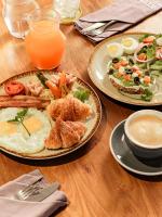 una mesa con platos de desayuno y zumo de naranja en The Grandiose Hotel Chiang Rai เดอะแกรนด์ดิโอสเชียงราย, en Chiang Rai