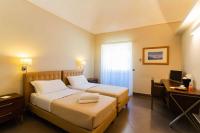 Łóżko lub łóżka w pokoju w obiekcie Le Magnolie Hotel