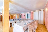 Habitación grande con una mesa larga con mesas y sillas blancas. en Hotel Badde Rosa, en Bolotana