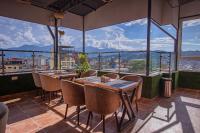 カトマンズにあるHotel Vistaraのテーブルと椅子と大きな窓のあるレストラン