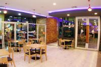 een restaurant met tafels en stoelen voor een winkel bij Arthitaya Green Nature Hotel & Lakkhana Poolside Resort in Noord Pattaya