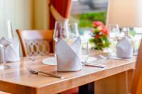 una mesa de madera con platos, tenedores y gafas en Hotel Unter den Linden, en Rüdesheim am Rhein