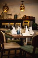a wooden table with napkins and glasses on it at Central Hotel Ridge in Accra