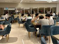 クウェートにあるDolphin Continental Hotelのレストランのテーブルに座っている人々のグループ