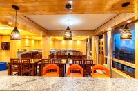 uma sala de jantar com cadeiras e mesas cor de laranja em The Golden Retreat Hotel in Pelling em Pelling