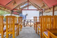 uma fila de mesas e cadeiras de madeira num restaurante em The Baysura Arugambay em Baía de Arugam