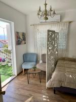 ein Wohnzimmer mit einem Bett, einem Stuhl und einem Fenster in der Unterkunft Suits יחידת נופש מתוקה באילת in Eilat