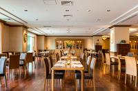 a dining room with wooden tables and chairs at GrandEmpireHotel in Onojo