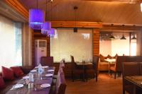 een eetkamer met tafels en stoelen en paarse verlichting bij Sparsh Hotel & Resort in Bareilly