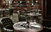 Un restaurante con mesas y sillas y un bar. en NJV Athens Plaza, en Atenas