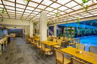 um restaurante com mesas e cadeiras de madeira e uma piscina em Greenhost Boutique Hotel Prawirotaman em Yogyakarta