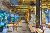 uma fileira de mesas e cadeiras em um restaurante em Greenhost Boutique Hotel Prawirotaman em Yogyakarta