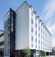 a large white building with a sign in front of it at Comfort Hotel Suzuka in Suzuka