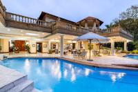 ein Haus mit einem Pool mit Sonnenschirm in der Unterkunft Christies at 32 on Russell in Nelspruit