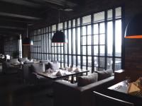 a restaurant with couches and tables and large windows at Hotel Dùa in Kaohsiung