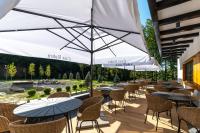 a row of tables and chairs with white umbrellas at Casa Roben in Rîu de Mori