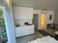 a kitchen with white cabinets in a room at Storchencamp Gästehaus Purbach in Purbach am Neusiedlersee