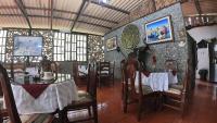 uma sala de jantar com mesas e cadeiras e uma parede de pedra em Hosteria Rio Verde em Río Verde