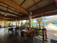 科隆EL RIO Y MAR RESORT的一间有桌椅、可欣赏海景的餐厅