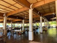 科隆EL RIO Y MAR RESORT的配有木桌、桌椅的餐厅