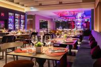 Un restaurante con mesas y sillas con copas de vino. en Adesso Hotel, en Roma