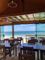 ein Restaurant mit Tischen und Strandblick in der Unterkunft Pousada Refugio Costeiro in Bombinhas