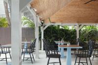 a patio with tables and chairs under a wooden ceiling at Ridley House - Key West Historic Inns in Key West